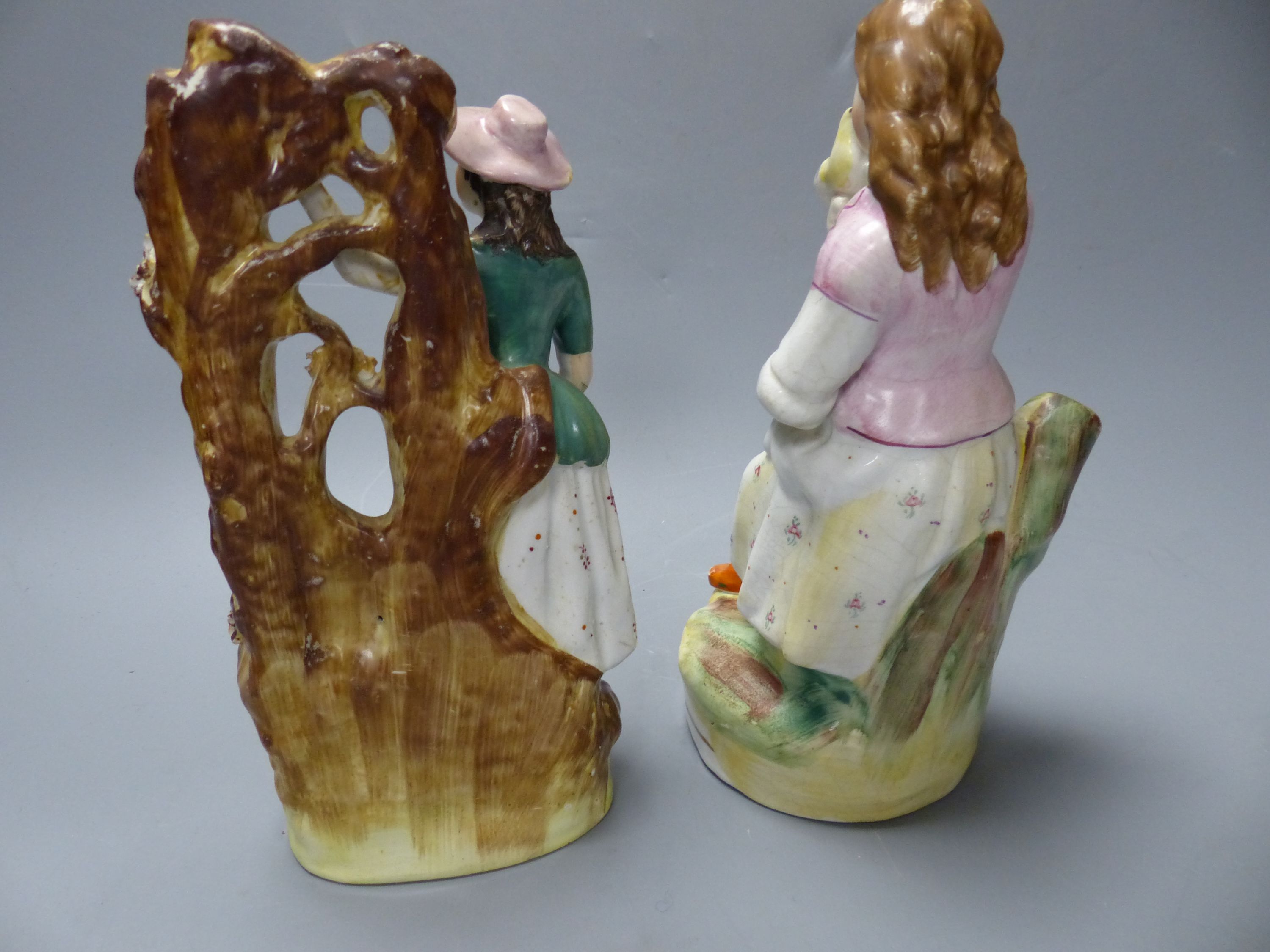 A Staffordshire figure of a female grape picker with vine bocage and three other figures
